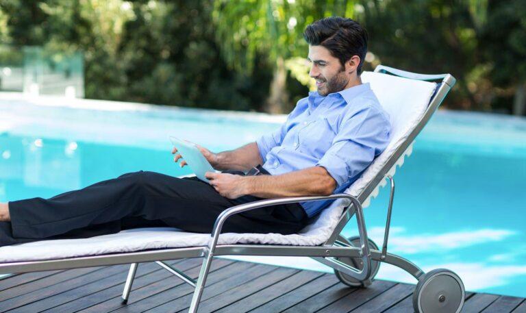 Smart man using digital tablet near pool