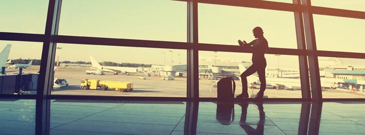 businesswoman using tablet computer at the airport. silhouette of a girl traveler with backpack. business and travel