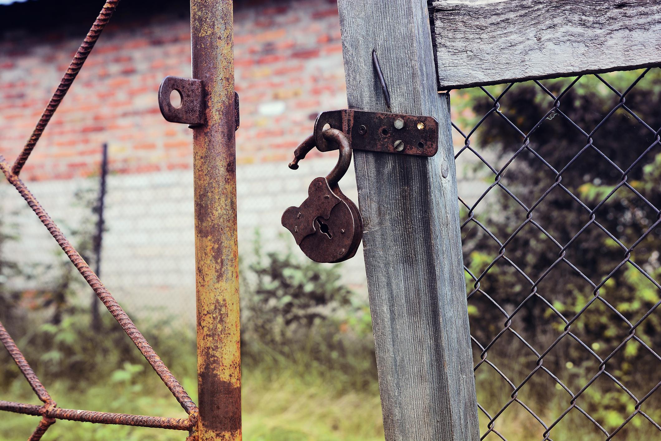 Rusty padlock on an old village gate. Intrusion Concept