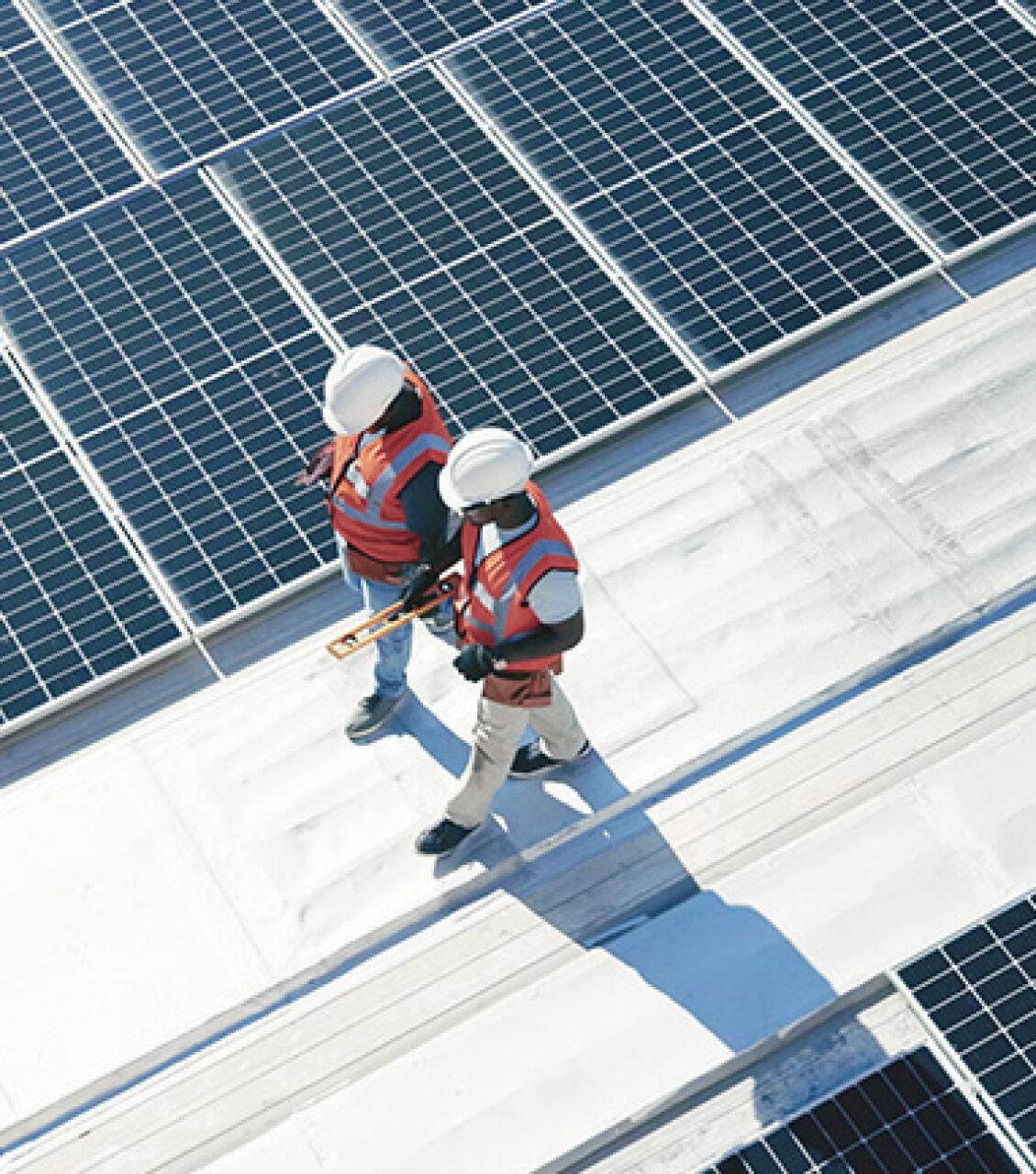 Two workers walking, wearing high visibility vests