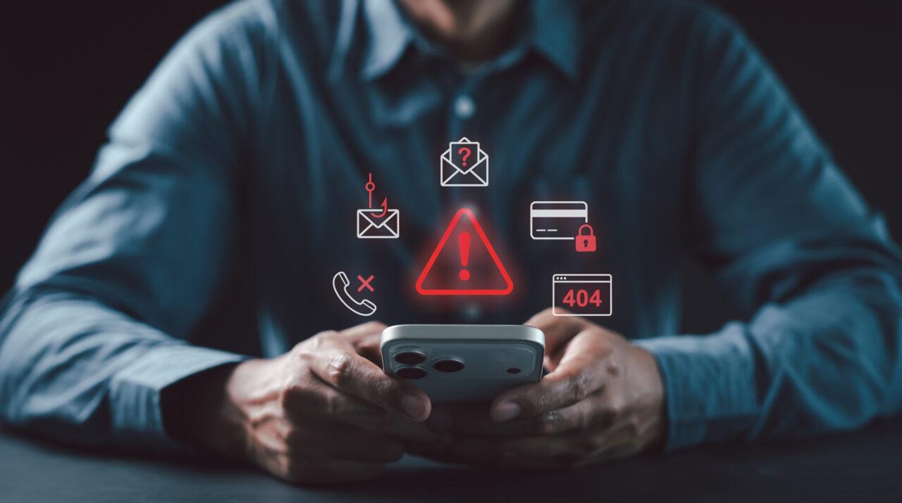 Man using smartphone virtual red cybersecurity warning icons Phishing, Call scam, Credit card fraud, 404 Error for online safety concept, OTP fraud, Attack Crime, Spyware Blacklist, Protection Crisis